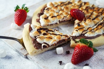 Homemade s'mores desser tpizzatopped with toasted marshmallows and chocolate drizzle