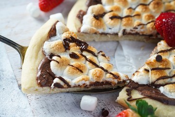 Homemade s'mores desser tpizzatopped with toasted marshmallows and chocolate drizzle