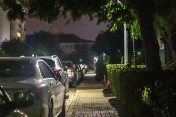 a nice looking narrow night shoot from sidewalk - there is many cars and street lights