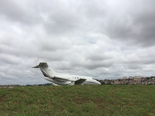 Private business jet being refueled in the airport courtyard on a cloudy day