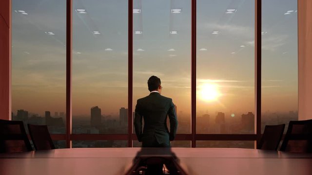 Business people watch the city at sunset.