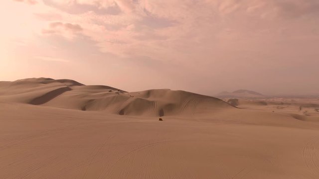 Dune buggy. Sandy desert oasis lake. DRONE. Adventure Dune Buggy. Speed. Tourism shot in Huacachina, Peru. Epic, Fast. Water in middle of hot sand desert. Romantic, holiday, honeymoon, scenic shot.
