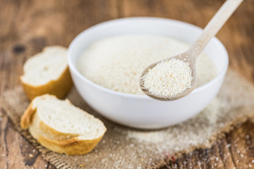 Vintage wooden table with Bread Crumbs (selective focus; close-up shot)