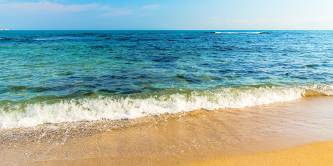 sea scenery in summer. beach with golden sand. wonderful vacation background with transparent calm waves and blue sky. panoramic view
