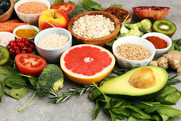 Healthy food clean eating selection: fish, fruit, vegetable, cereal, leaf vegetable on rustic background