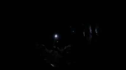 Cavers searching shining their head lamp around inside cave 
