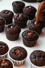 Cooking chocolate cream cupcakes. Confectioner cooks in kitchen.