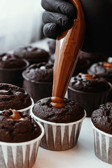 Cooking chocolate cream cupcakes. Confectioner cooks in kitchen.