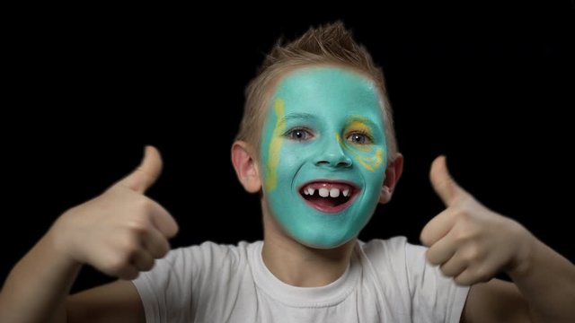 Happy boy rejoices victory of his favorite team of Kazakhstan. A child with a face painted in national colors. Portrait of a happy young fan. Joyful emotions and gestures. Victory. Triumph.
