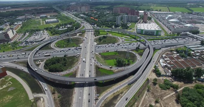 Aerial distant view of huge two level intersection with circular traffic. Transport infrastructure in metropolis. Moscow cityscape, Russia