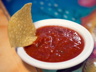 A tortilla chip dipped in salsa.