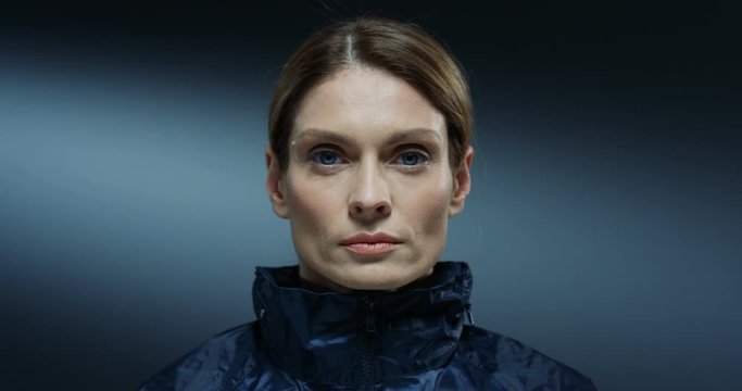 Close up of the serious face of the Caucasian beautiful young woman FBI agent looking straight at the camera. Portrait.