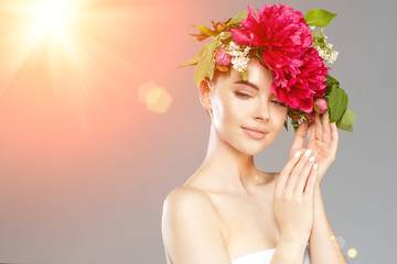 Beauty woman with flowers on head. Happy beautiful girl on gray banner background. Pretty model with clear skin. Spring fashion photo. Summertime portrait