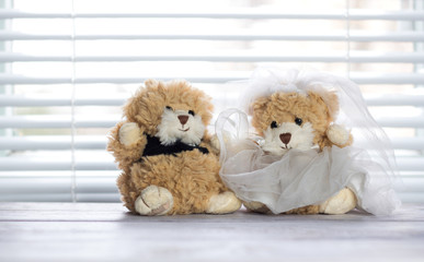 Wedding teddy bears. Teddy bears in wedding dresses are sitting near the window.