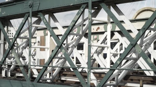 Close-up view of the white wagon going rapidly on the bridge against the blue sky. Action. Urban rail transport