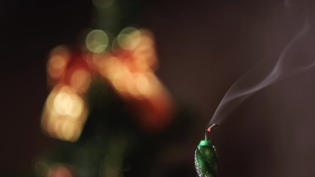 Close-up of Christmas extinct candle against the blurred Christmas tree silhouette with lights and decorations. Concept. Christmas mood