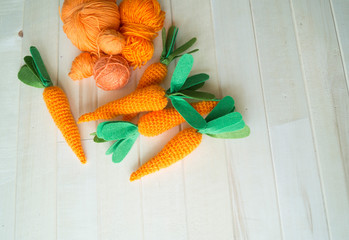 Knitted carrot. Threads and knitting needles in a basket.