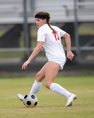 Obraz premium Young athletic girl playing in a soccer match