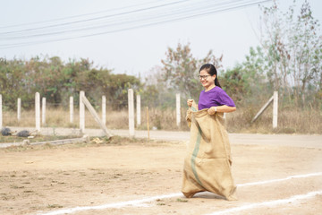 Thai woman doing sack race or running game