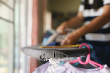 Asian mother laundry and using steam ironing