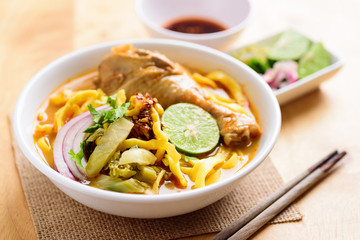Northern Thai food (Khao Soi Kai), spicy egg noodles soup with chicken in a bowl