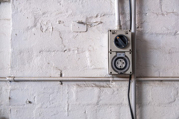 Industrial 10 amper power outlet mounted to a workshop wall with copy space