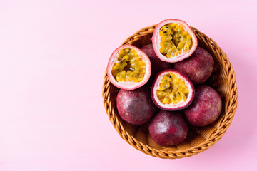 Fresh passion fruit in basket on pink background