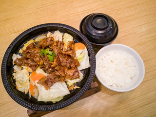 spicy grilled beef rice set close up shot on a wooden table.