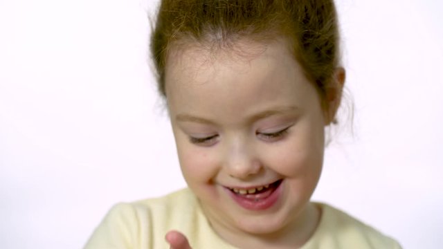 Cute girl of six years old shows a Bitcon gold coin in her hand. Close-up on a white background. The future of cryptocurrency.
