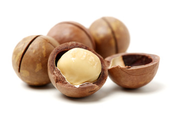 Shelled and unshelled macadamia nuts on white background 
