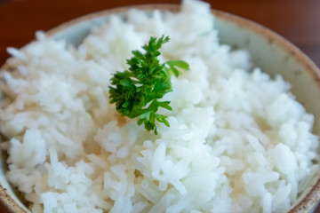 Small bowl of white rice with vegetable decorated on top.