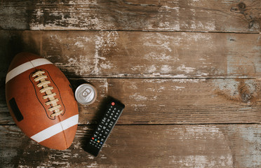 Football and Remote on Wooden Background