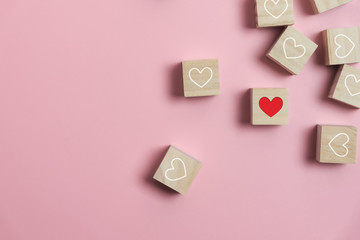 Heart in Wooden cubes on pink background.