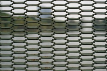 A grid metal fence in the park.