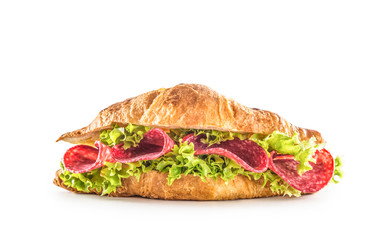 Croissant stuffed with lettuce salad and salami isolated on white background