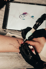 girl stuffs tattoo on woman leg closeup, sterility