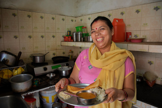 portrait of a smiling woman offering food	
