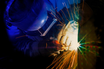 industrial worker is welding a metal structure for support pipeline