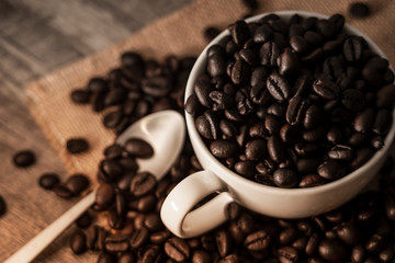 coffee photography background by selective focus at the roast coffee beans on a white coffee cup