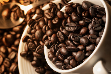 coffee photography background by selective focus at the roast coffee beans on a white coffee cup