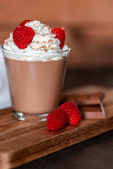 Homemade chocolate mousse with whipped cream, raspberries and chocolate shavings on top