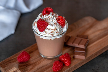 Homemade chocolate mousse with whipped cream, raspberries and chocolate shavings on top