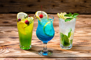 green fairy cocktails with lemon and absinthe, a blue lagoon and mojito in a bar