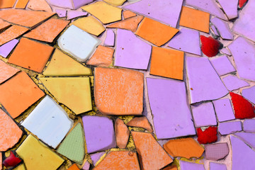 many colorful piece of broken ceramic embled  in the wall.