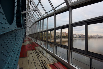 structural elements of a closed bridge with a panoramic view of the river and the city