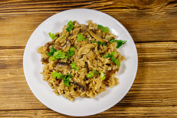 Tasty risotto with mushrooms on wooden table. Top view
