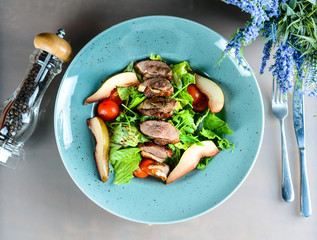 roast duck with pear and fresh salad on the table