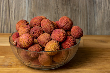 Lychee. Bowl with lychee on a wooden background.