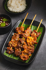 Grilled pork with sticky rice and thai spicy sauce and ingredients. Moo ping is grilled pork in traditional Thai style food. Oily grilled pork will rise cholesterol.