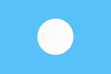 white plastic cap for jar isolated on blue, top view